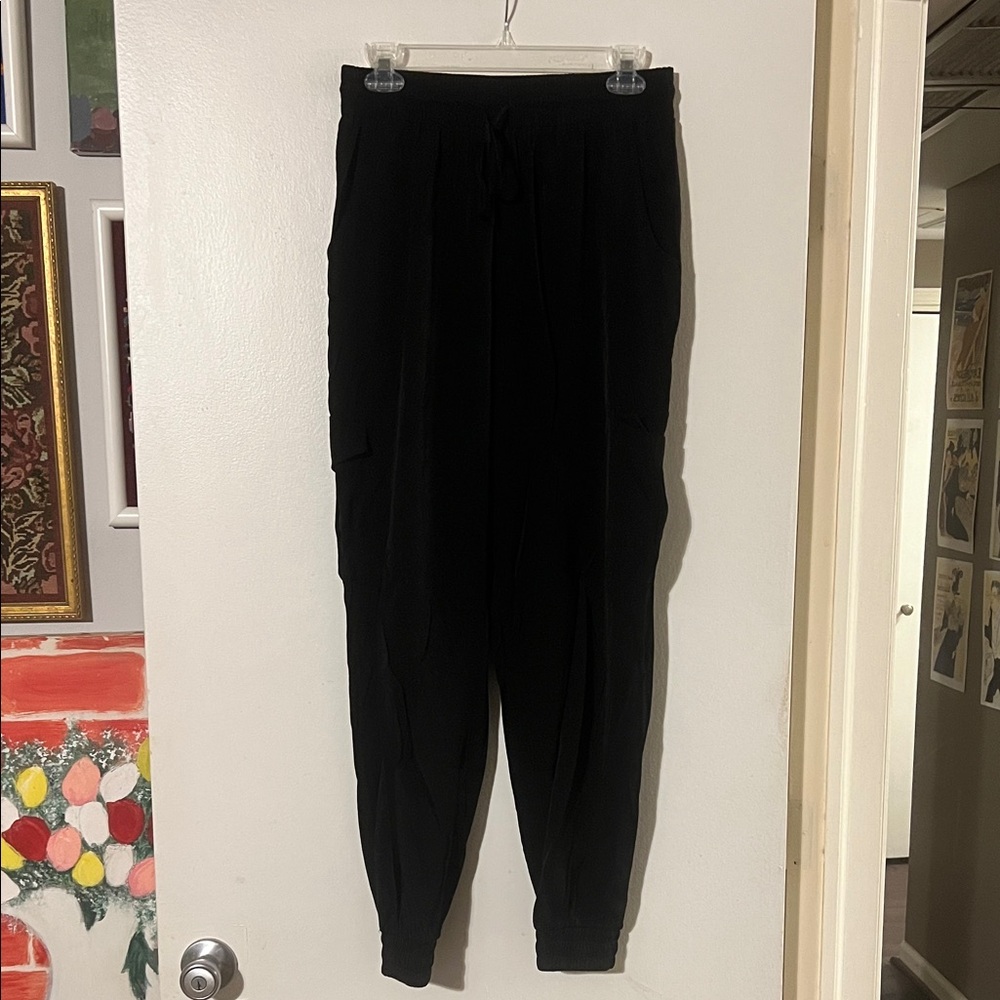 Pinch black elastic waist and ankle cargo pants. Flap pockets on side thigh